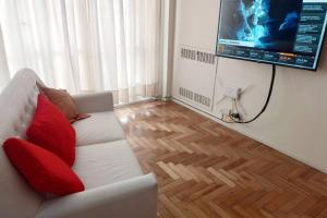 a living room with a white couch and a flat screen tv at Confortable departamento en Retiro in Buenos Aires