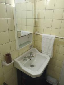 La salle de bains est pourvue d'un lavabo blanc et d'un miroir. dans l'établissement Confortable departamento en Retiro, à Buenos Aires