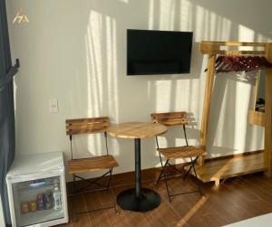 a room with a table and two chairs and a television at HA PLEIKU in Pleiku