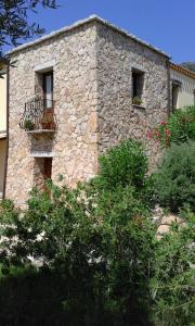 un edificio in pietra con due finestre e un balcone di Hotel Cardedu a Cardedu