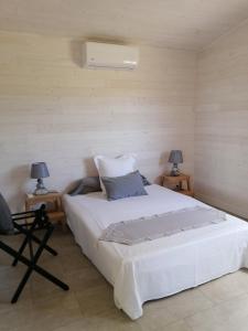 a bedroom with a large white bed with two lamps at NIAOULI LODGE in Bourail