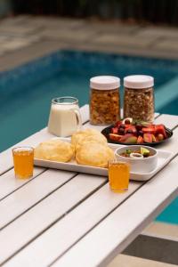 ein Tablett mit Essen auf einem Tisch neben einem Pool in der Unterkunft The Highlander in Vagamon