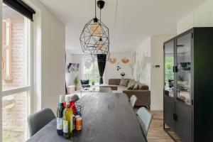una sala da pranzo e un soggiorno con tavolo di Het Huys Ewijk mooi luxe en een laadpaal a Ewijk