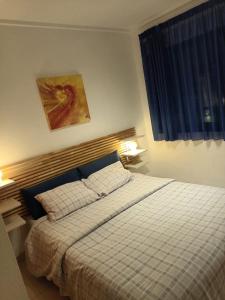 een slaapkamer met een bed met een geruite deken en een raam bij Apartamento confortable en la bahia de Alicante in Alicante