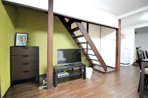 Yagara Terrace House D في أوساكا: غرفة معيشة مع تلفزيون ودرج