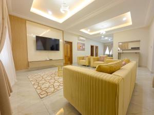 a living room with a couch and a flat screen tv at The AUD Luxury Apartments in Kumasi