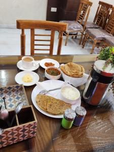 einen Tisch mit Teller mit Speisen und Brot in der Unterkunft Airport Hotel Claytone in Neu-Delhi