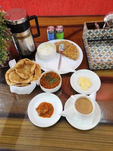 una mesa con platos de comida y tazones de inmersión en Airport Hotel Claytone en Nueva Delhi