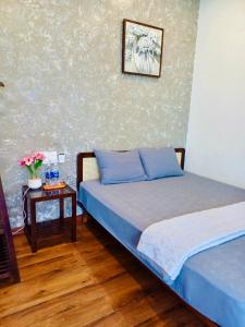 a bedroom with two beds and a table with flowers at Boom Casa Homestay in Hue
