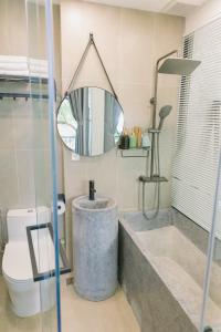 a bathroom with a sink and a toilet and a mirror at Boom Casa Homestay in Hue
