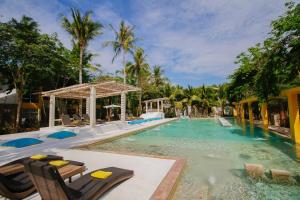 a swimming pool with chaise lounge chairs in a resort at Summer Luxury Beach Resort & Spa in Baan Tai