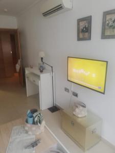 een woonkamer met een flatscreen-tv aan de muur bij Apartamento confortable en la bahia de Alicante in Alicante