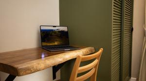 a laptop computer sitting on top of a wooden table at Hotel Boutique Los Abetos in Boquete