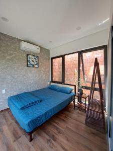 Un dormitorio con una cama azul y una escalera en Boom Casa Homestay, en Hue