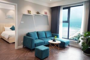 un soggiorno con divano blu e letto di Armin Homes Altara Residences Quy Nhon a Quy Nhon