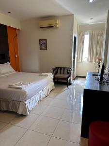 ein Hotelzimmer mit 2 Betten und einem Schreibtisch in der Unterkunft Cozy Place in Patong Beach