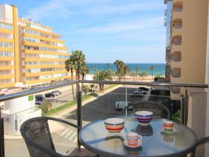 una mesa con tazas en un balcón con vistas al océano en Apartamento Roses, 2 dormitorios, 6 personas - ES-258-66, en Roses
