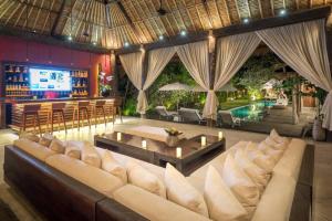 sala de estar con sofá, mesa y piscina en Sunset Beach Villa Zanzibar, 