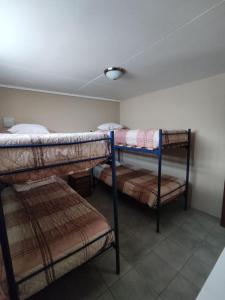 um quarto com 3 beliches e um tecto em departamento independiente, cerca de todo em San Pedro de Atacama