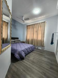 una camera con letto viola e specchio di Thetamu Homestay مسلم Pesona a Jalan Baharu