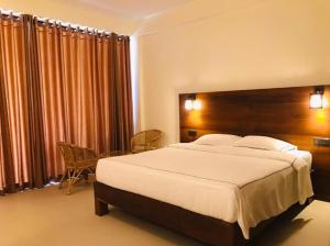 a bedroom with a large bed with a wooden headboard at Mandara Mount Hotel in Ella