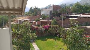 uma vista para um jardim a partir de uma casa em CASA DE CAMPO COCACHACRA LODGE em Cocachacra