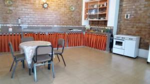 uma cozinha com uma mesa, cadeiras e um fogão em CASA DE CAMPO COCACHACRA LODGE em Cocachacra