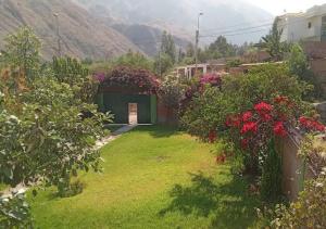 einen Garten mit Blumen und Sträuchern und ein Gebäude in der Unterkunft CASA DE CAMPO COCACHACRA LODGE in Cocachacra