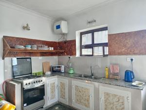 a kitchen with a stove and a sink at Seafarers Loft in Stone Town