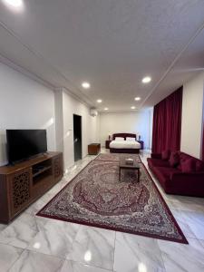 uma grande sala de estar com um sofá e uma televisão em بيت السلطانة للأجنحة الفندقية em Salalah