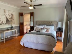 Un dormitorio con una cama y un ventilador de techo. en Middleton House Maleny, en Witta