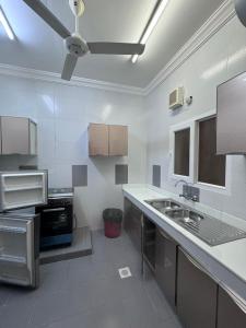 a kitchen with white walls and a ceiling at بيت السلطانة للأجنحة الفندقية in Salalah