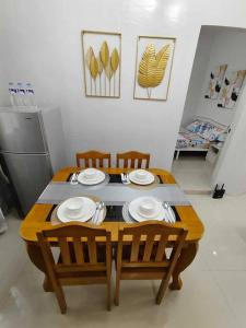 a table with chairs and plates on top of it at JADEN Guesthouse in Davao City