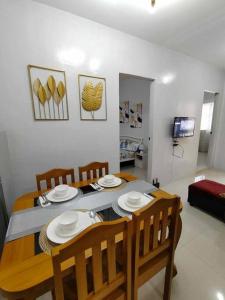 a dining room with a table and chairs and a television at JADEN Guesthouse in Davao City