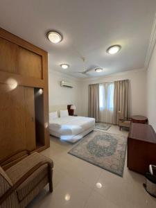 サラーラにあるبيت السلطانة للأجنحة الفندقيةのベッドとデスクが備わるホテルルームです。