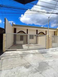 uma cerca branca em frente a uma casa em JADEN Guesthouse em Davao