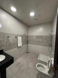 بيت السلطانة للأجنحة الفندقية في صلالة: حمام مع مرحاض ومغسلة
