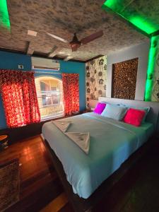 um quarto com uma cama grande e almofadas coloridas em Beach Paradise Day Cruise Houseboat - VACCINATED STAFF em Alappuzha