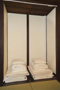 two stacks of white towels in a closet at Yagara Terrace House B in Osaka