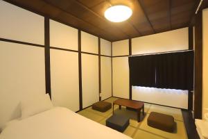 a room with a bed and a table and a window at Yagara Terrace House B in Osaka