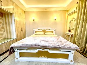 1 dormitorio con 1 cama blanca en una habitación en National Luxury Apartments DHA - 3 BedRoom opposite Airport, en Lahore