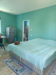 un grande letto in una stanza con pareti blu di Chill land house a Bang Tao Beach