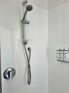 un soffione della doccia appeso a un muro in bagno di Burkes Pass Country Motels a Burkes Pass
