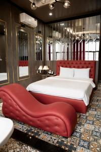 - une chambre avec un grand lit et un pouf rouge dans l'établissement Tuyet Suong Hotel, à Quảng Ngãi