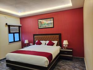 的住宿－REVATI MAHAL，一间卧室设有一张带红色墙壁的大床