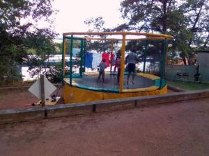 people are playing in a play structure in a park at Camping Hurongues in Pomeys