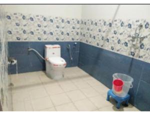 een badkamer met een toilet en een emmer erin bij Hotel Ajay, Phata in Phata
