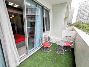 a balcony with four chairs and a red seat at Cozy Apartment with Lagoon View in Manila