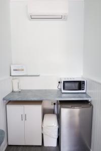 a kitchen with a counter with a microwave and a refrigerator at Robetown Motel in Robe