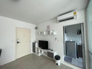 a white room with a television and a door at Living like local in Chiangmai in Chiang Mai